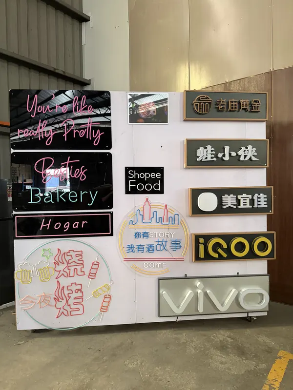 The sample wall in daylight: acrylic backings, box-up letters and a lit logo panel.